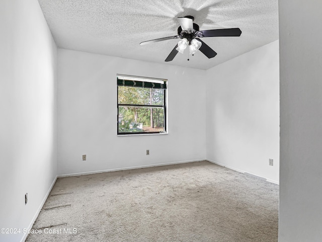 spare room featuring a textured ceiling, carpet floors, and ceiling fan