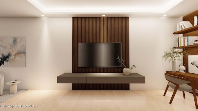 living room with light hardwood / wood-style floors and a raised ceiling