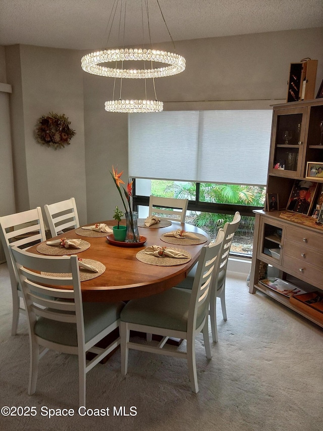 carpeted dining room featuring a textured ceiling