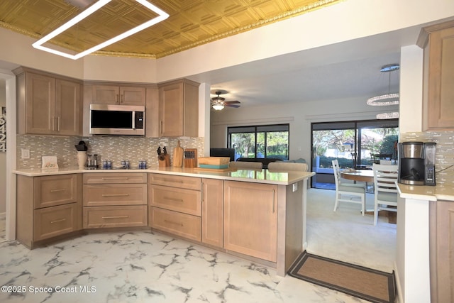 kitchen with black electric stovetop, ceiling fan, backsplash, and kitchen peninsula