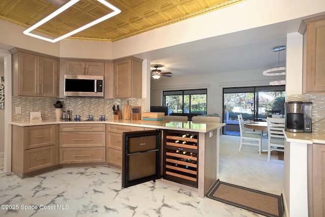 kitchen featuring tasteful backsplash, black electric cooktop, ceiling fan, kitchen peninsula, and wine cooler