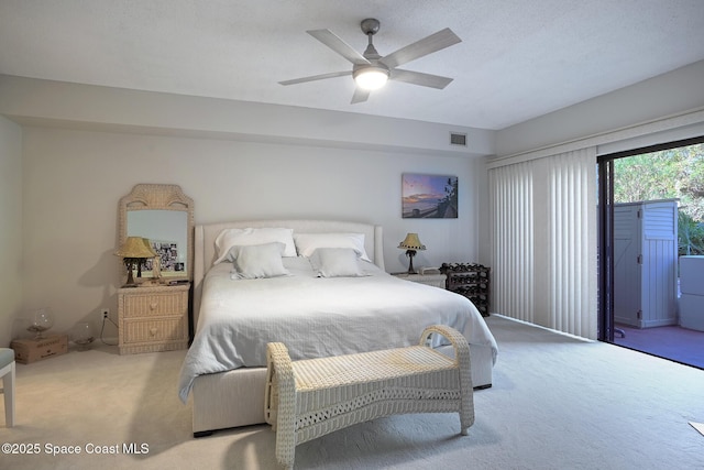 carpeted bedroom featuring ceiling fan, access to exterior, and a textured ceiling