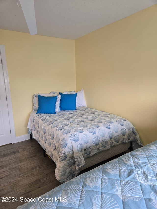 bedroom featuring dark wood-style flooring and baseboards