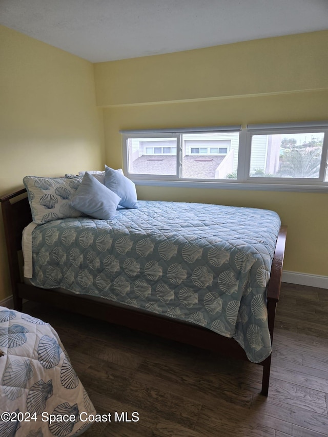 bedroom with dark wood finished floors and baseboards