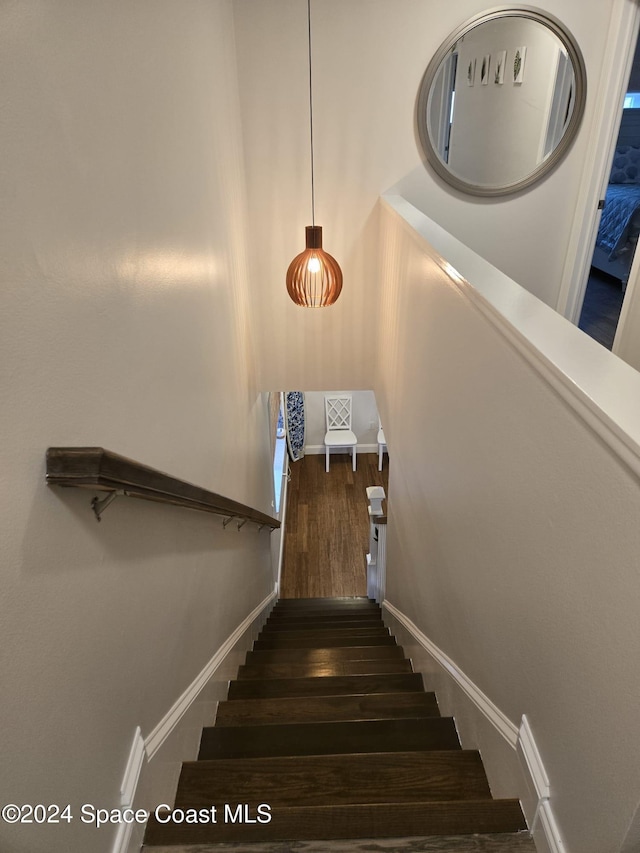 stairway featuring baseboards and wood finished floors