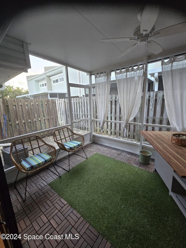 unfurnished sunroom with a ceiling fan