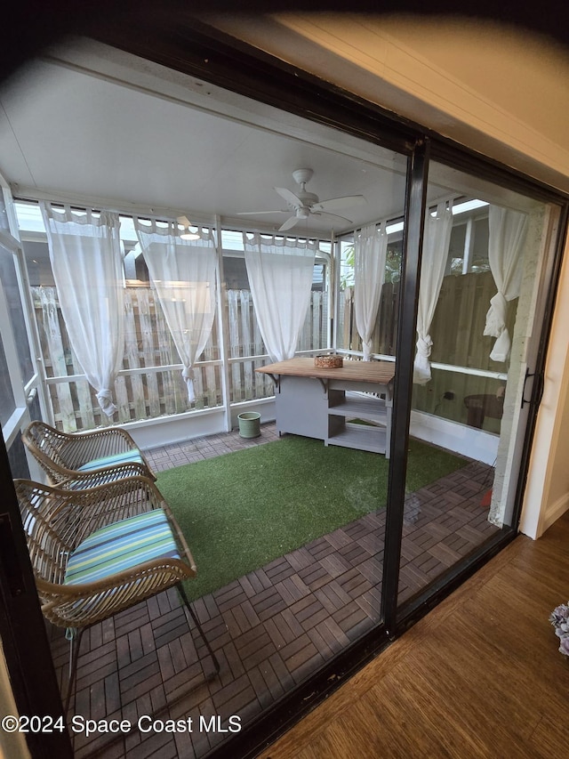 unfurnished sunroom featuring ceiling fan