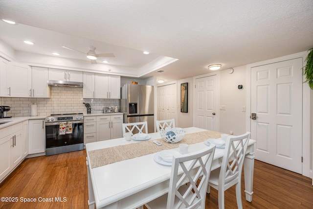 kitchen featuring appliances with stainless steel finishes, light countertops, light wood-style floors, and white cabinetry