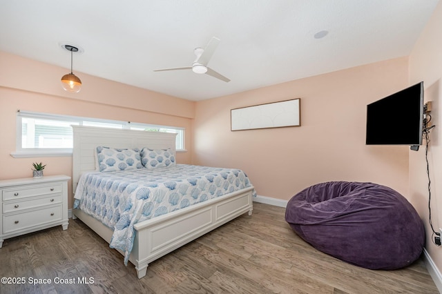 bedroom featuring ceiling fan, light wood-type flooring, and baseboards