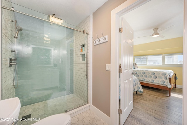 bathroom with toilet, ceiling fan, a shower with shower door, and wood-type flooring