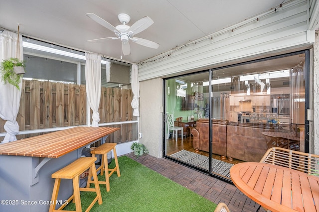 sunroom featuring ceiling fan and plenty of natural light