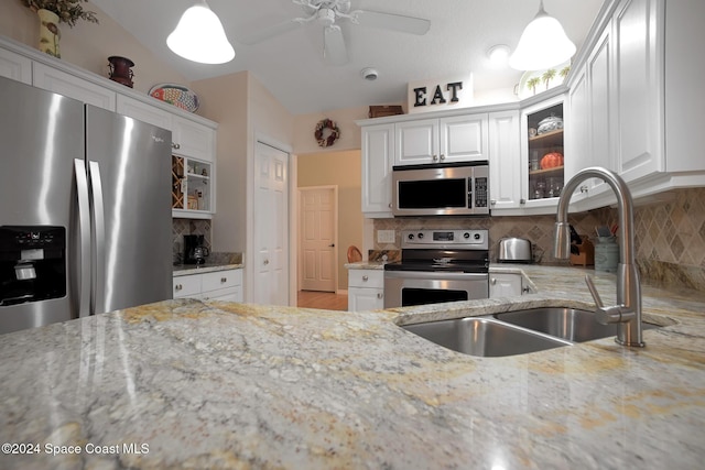 kitchen featuring backsplash, white cabinets, stainless steel appliances, and hanging light fixtures