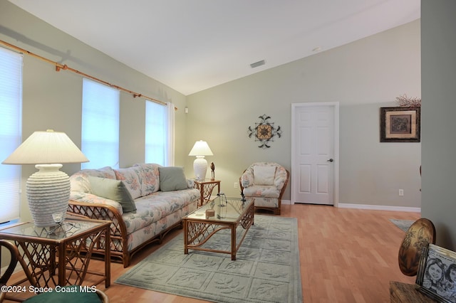 living room featuring light hardwood / wood-style floors and vaulted ceiling