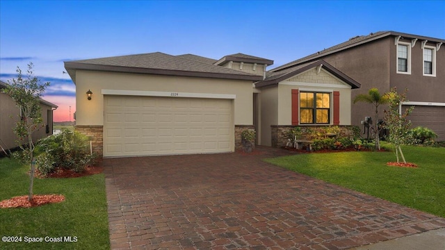 view of front of house featuring a garage and a lawn