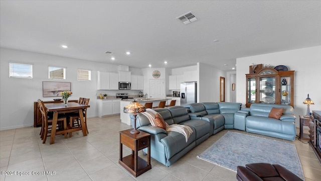 living room featuring plenty of natural light, sink, and light tile patterned floors