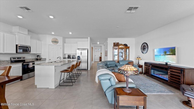 living room featuring sink and light tile patterned floors