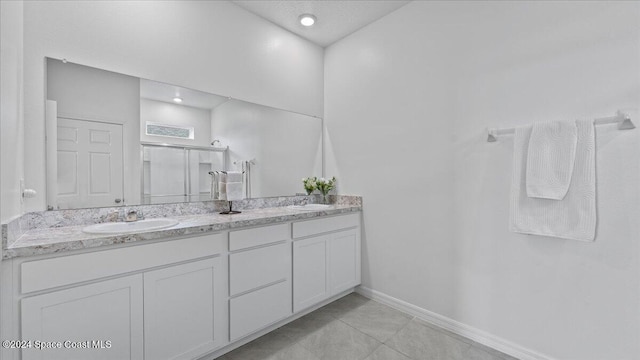 bathroom featuring vanity, tile patterned floors, and a shower with shower door