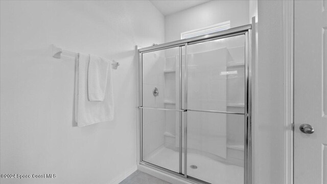 bathroom with a shower with door