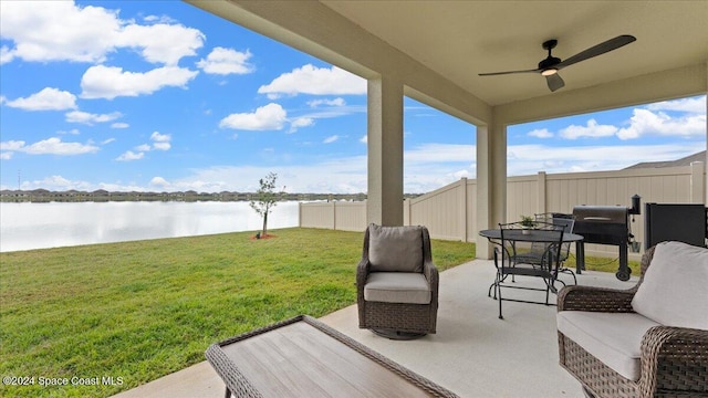 view of patio featuring a water view and ceiling fan