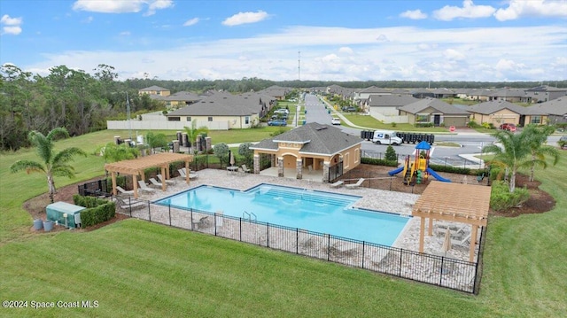 view of pool with a lawn, a pergola, and a playground