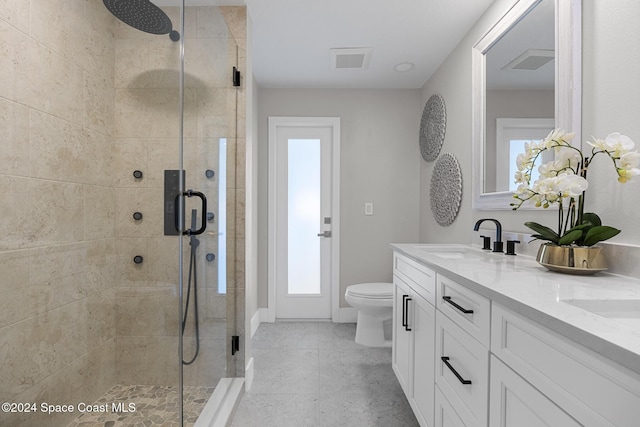 bathroom featuring tile patterned flooring, vanity, toilet, and walk in shower