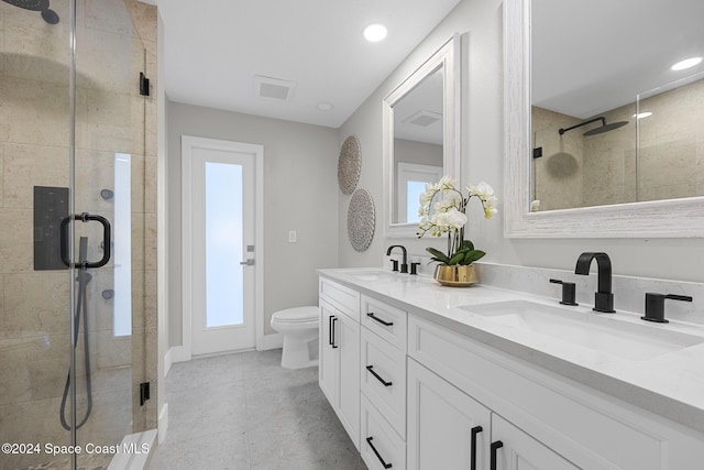 bathroom with tile patterned flooring, vanity, toilet, and a shower with door