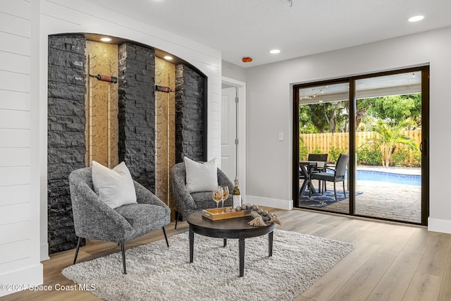 living area featuring wood-type flooring and a textured ceiling