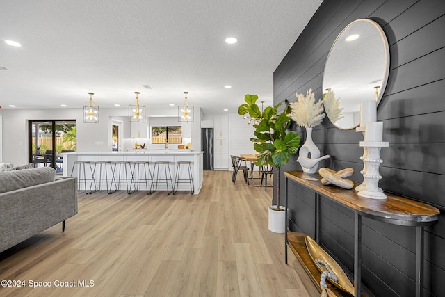 living room featuring light wood-type flooring and a textured ceiling