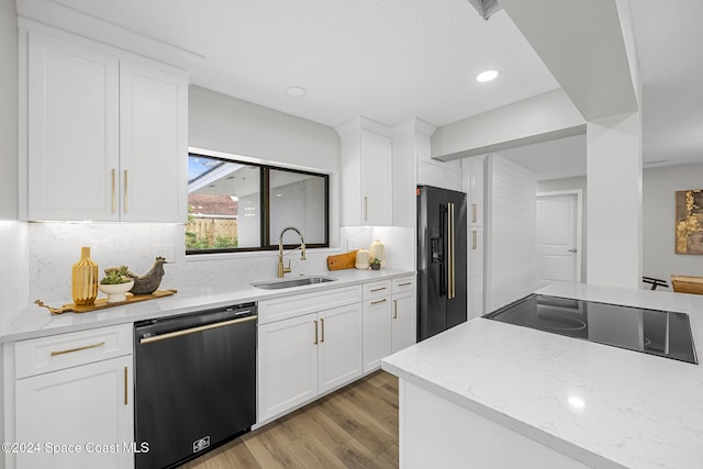 kitchen with white cabinetry, sink, backsplash, light hardwood / wood-style floors, and appliances with stainless steel finishes