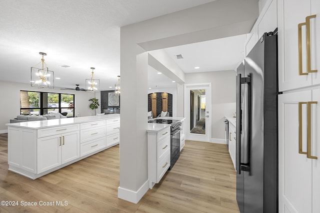 kitchen with white cabinetry, pendant lighting, stainless steel appliances, and light wood-type flooring