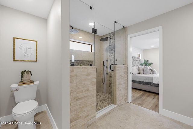 bathroom featuring tile patterned floors, toilet, and walk in shower