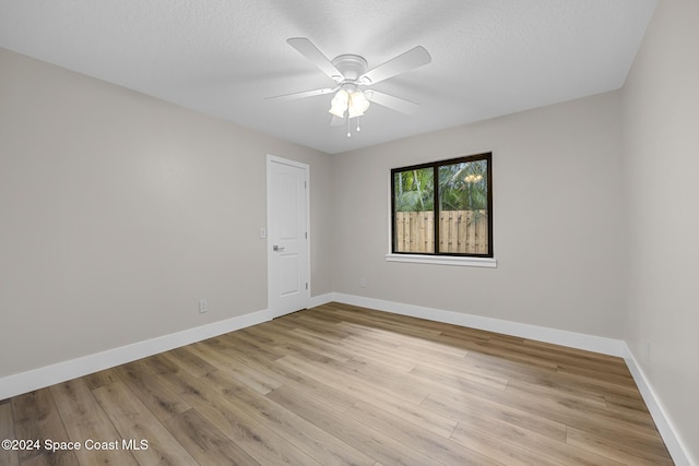 unfurnished room featuring ceiling fan, a textured ceiling, and light wood-type flooring