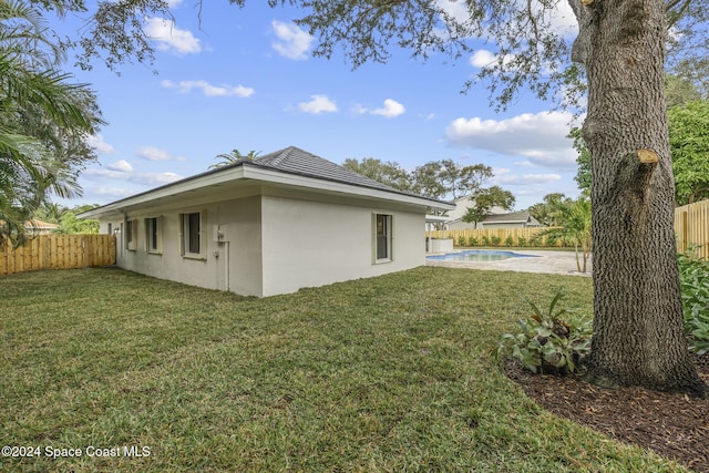 view of property exterior featuring a fenced in pool and a lawn