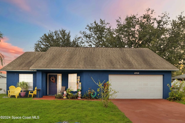 ranch-style home with a garage and a lawn