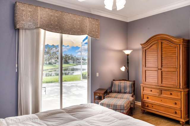 bedroom with a water view, ornamental molding, access to outside, and multiple windows