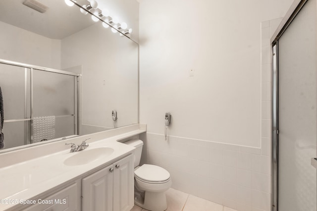 bathroom with an enclosed shower, tile patterned floors, tile walls, and toilet