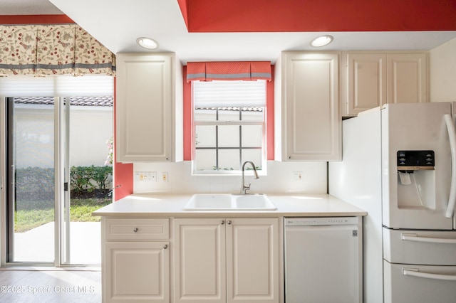 kitchen featuring white appliances, sink, and a wealth of natural light