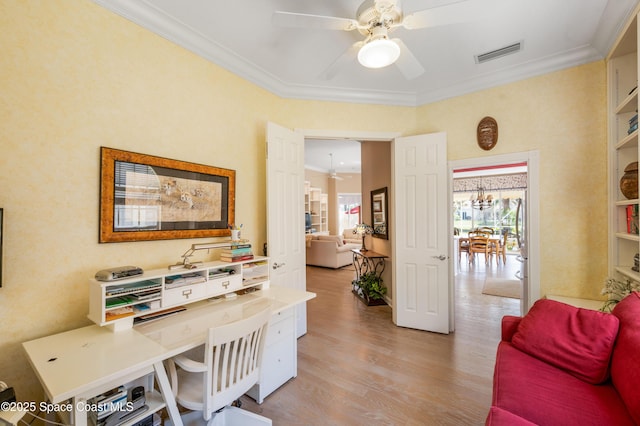 office with light hardwood / wood-style flooring, ceiling fan with notable chandelier, and ornamental molding