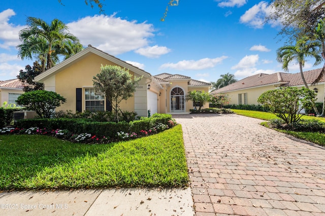 mediterranean / spanish home with a garage and a front lawn