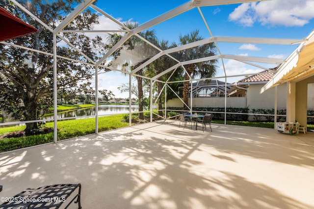 view of patio with a water view and a lanai