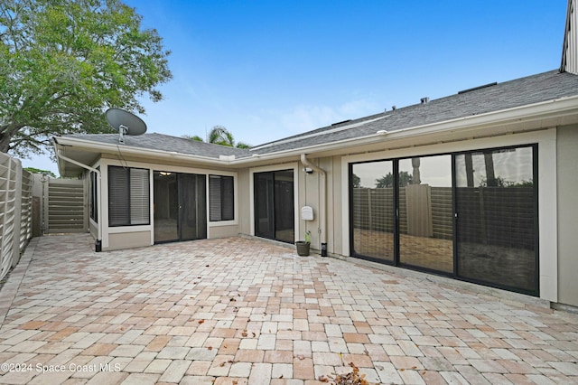 rear view of property with a sunroom and a patio area