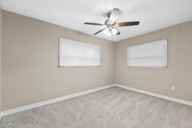 unfurnished room featuring light colored carpet and ceiling fan