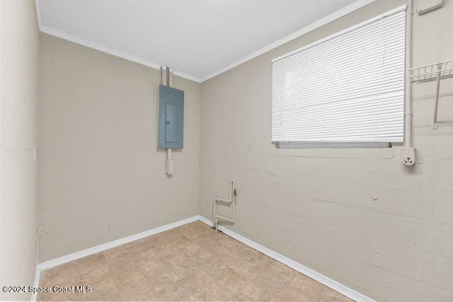 empty room with electric panel and ornamental molding