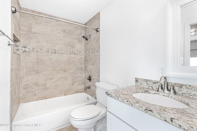 full bathroom featuring vanity, toilet, and tiled shower / bath