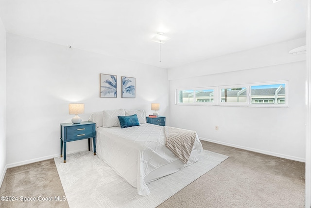 bedroom featuring light carpet and multiple windows