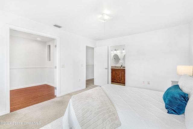 carpeted bedroom featuring ensuite bathroom