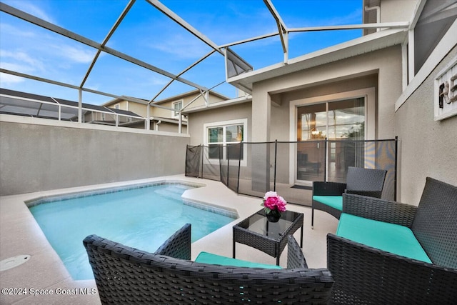 view of pool with outdoor lounge area, a lanai, and a patio