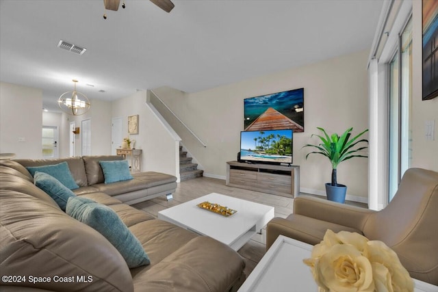 living room featuring ceiling fan with notable chandelier and a healthy amount of sunlight