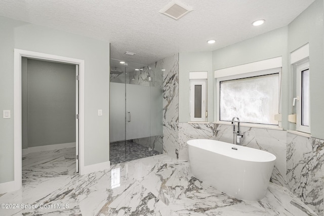 bathroom with tile walls, a textured ceiling, and shower with separate bathtub