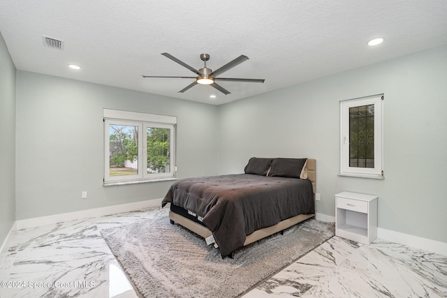 bedroom featuring ceiling fan and a textured ceiling